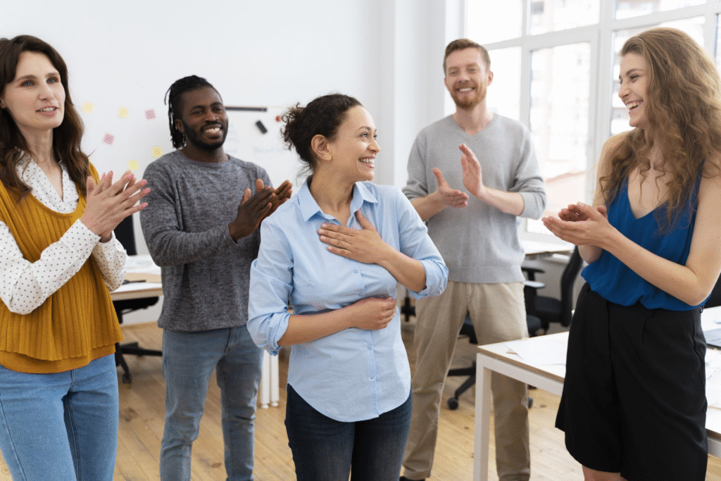 Cohésion d'équipe, une femme est applaudit par ses collègues.